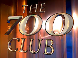 The logo of The 700 Club on a wooden background.