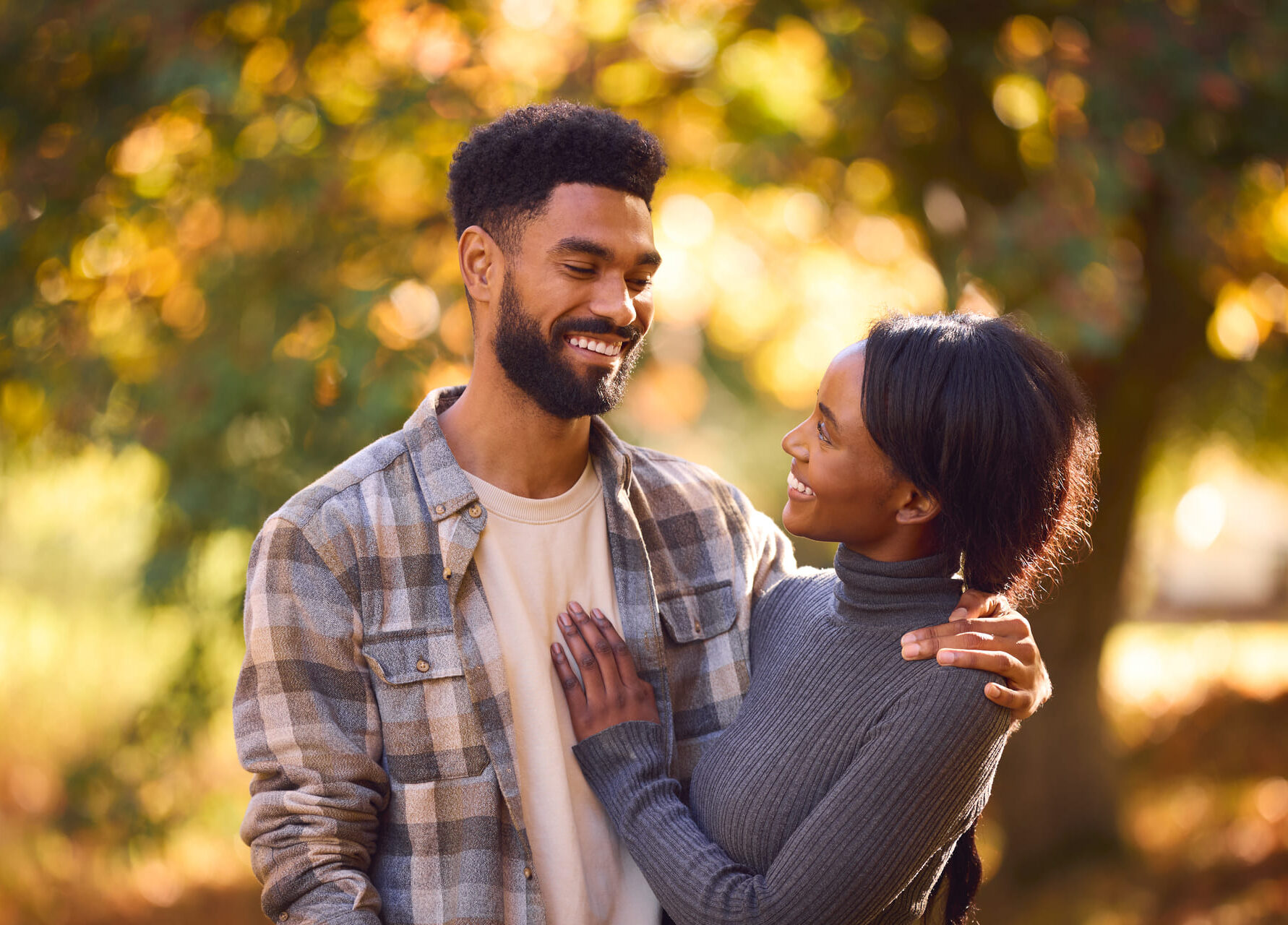 A happy couple sharing a moment outdoors in autumn.
